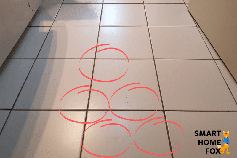 Der zurückgelassene Dreck des Yeedi Mop auf einem Fliesenboden wird in der Nahaufnahme gezeigt